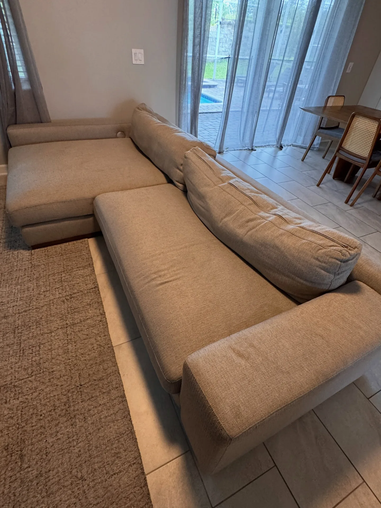 Light sectional sofa from the reverse angle before professional upholstery cleaning by Everglades Cleaning Solution